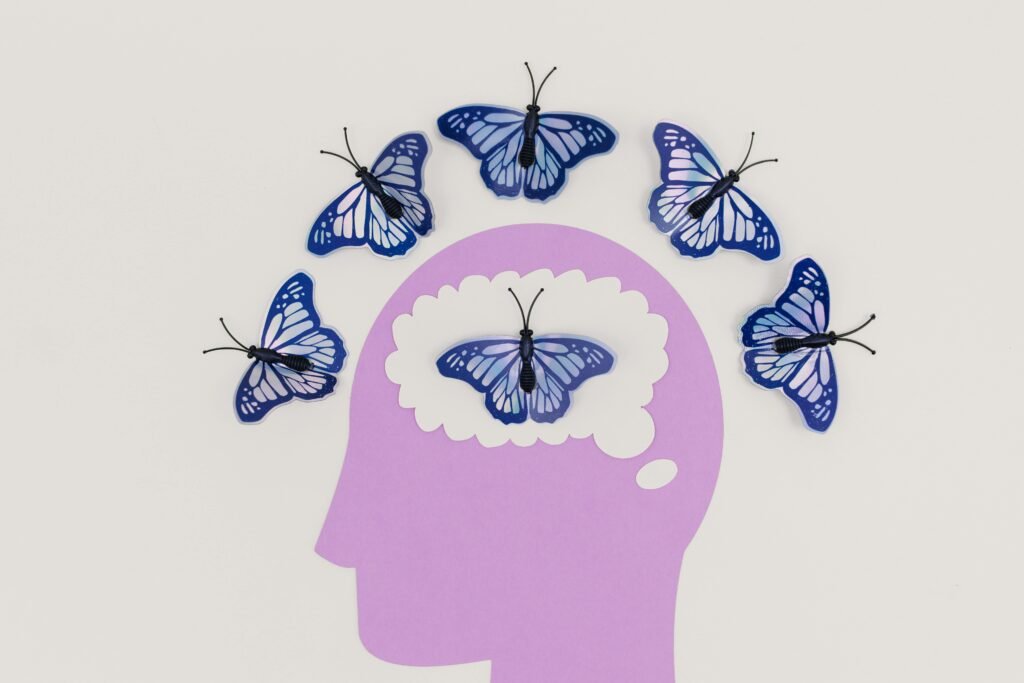 Creative illustration of butterflies representing thoughts over the silhouette of a brain—depicting the transformation of mental health.